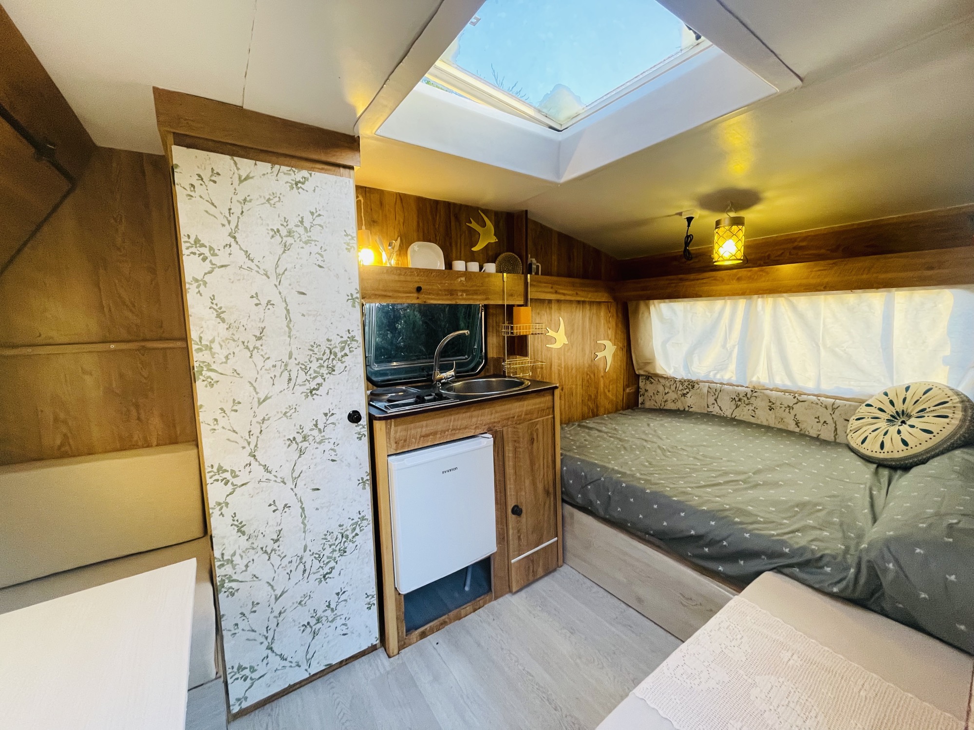 Interior caravana — cama y claraboya de luz